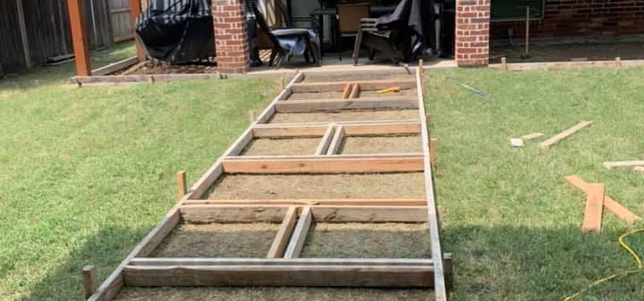 Wood forms laid out for a walkway through a yard